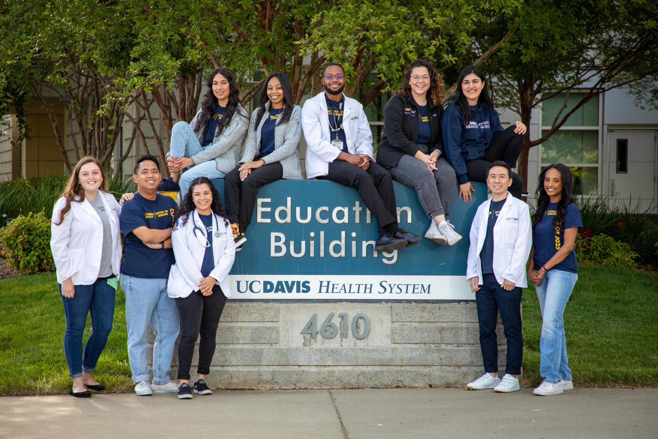 medical school students around education building sign